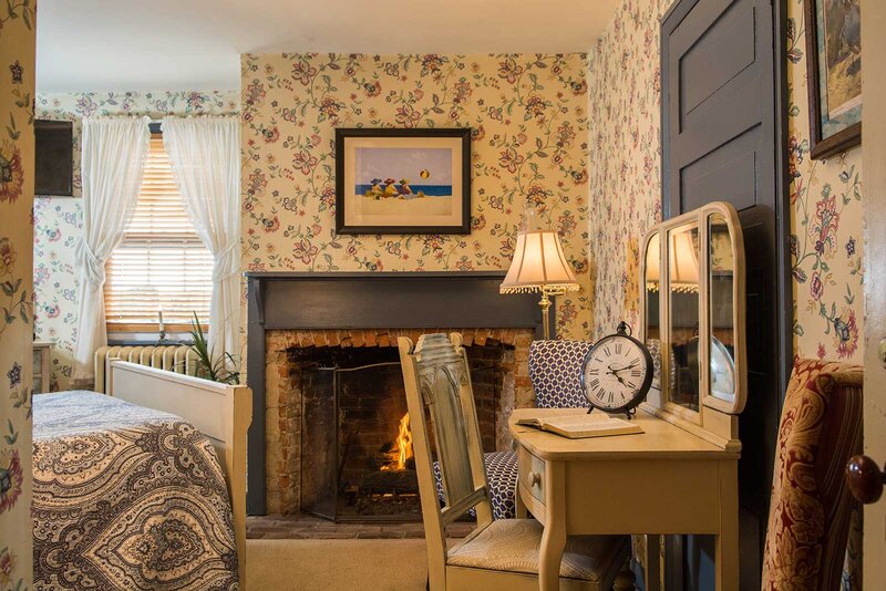 George Wheaton room with fireplace, desk and bed